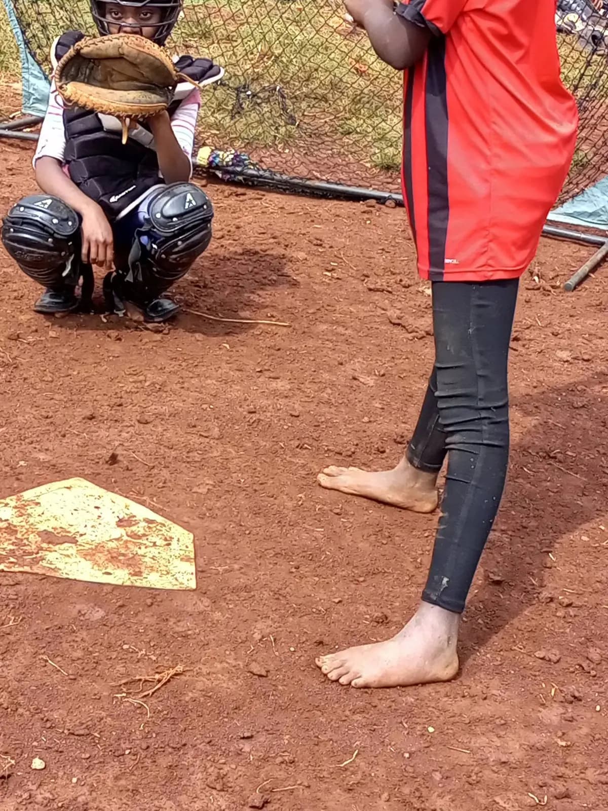 A barefoot player at home plate